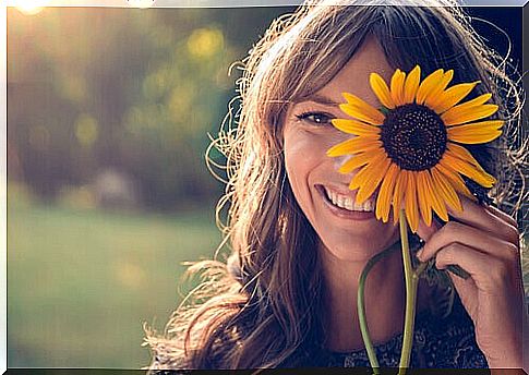 Girl with sunflower covering part of her face