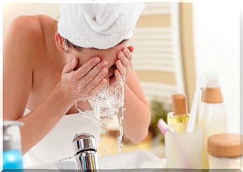 Woman washing her face with rice water to combat oiliness on her skin.